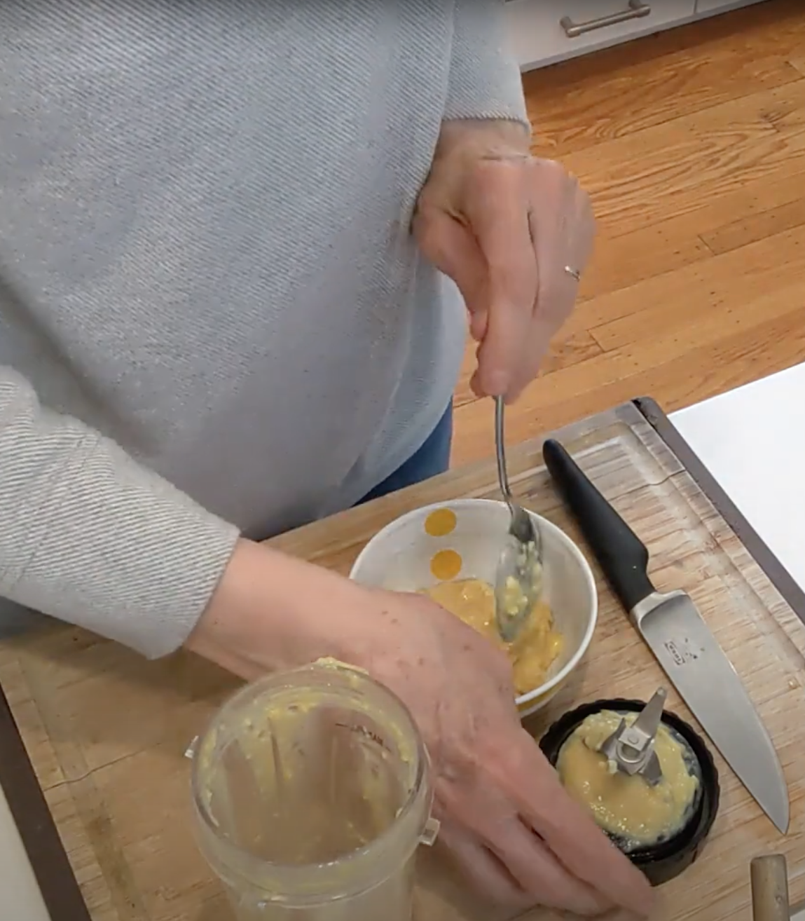 a person spooning lemon paste from a food processor