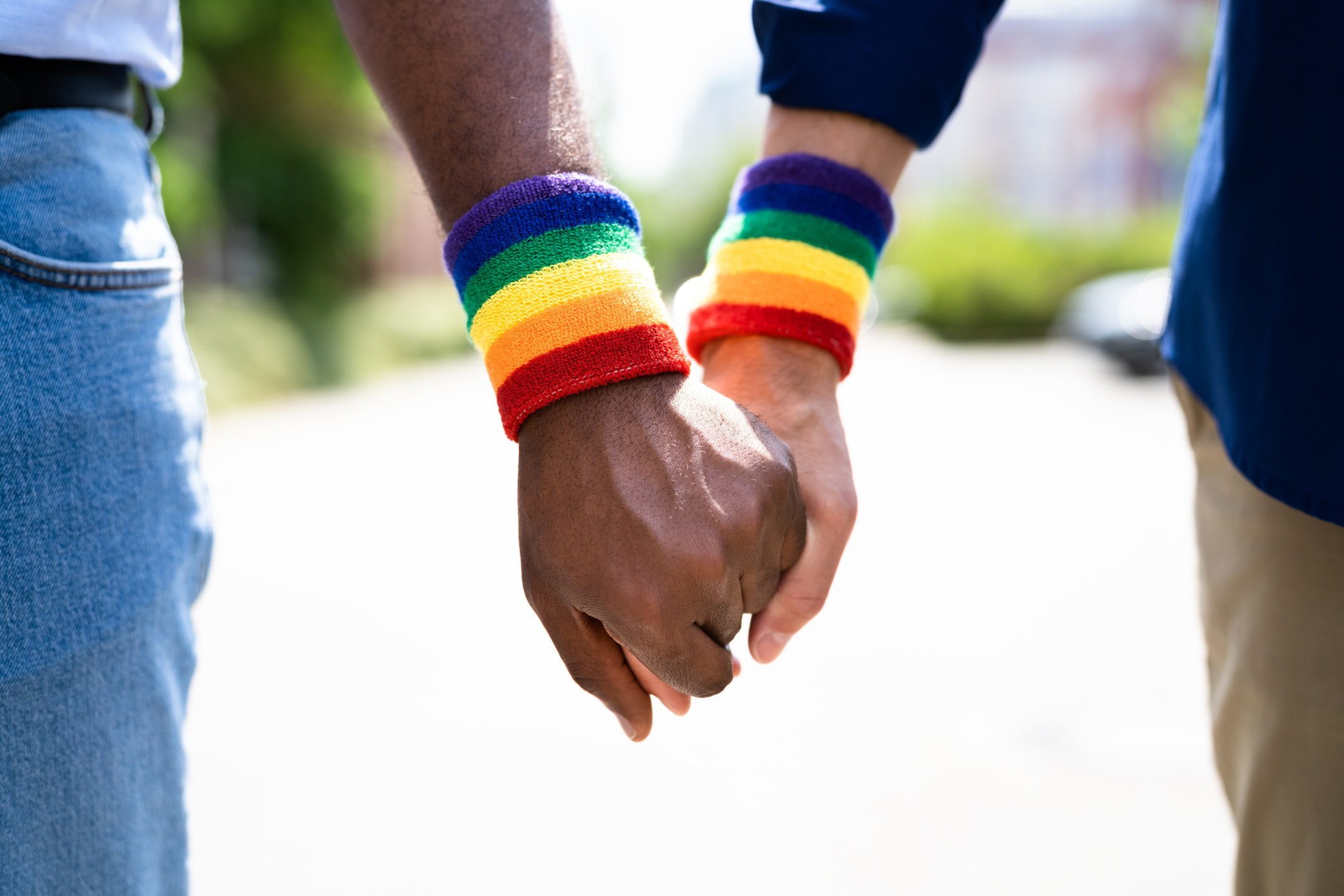 close up of hands being held with rainbow bracelets