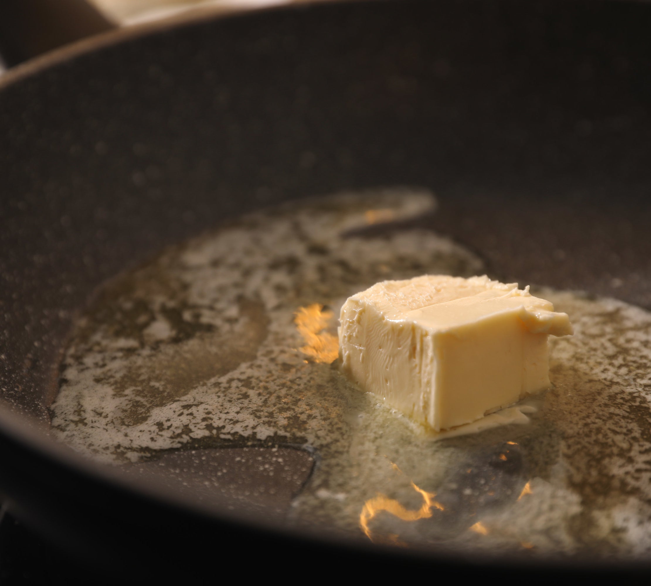 a thick slab of butter melting in a pan