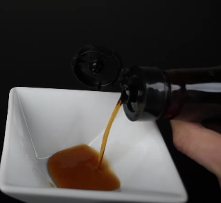 fish sauce being poured into a bowl