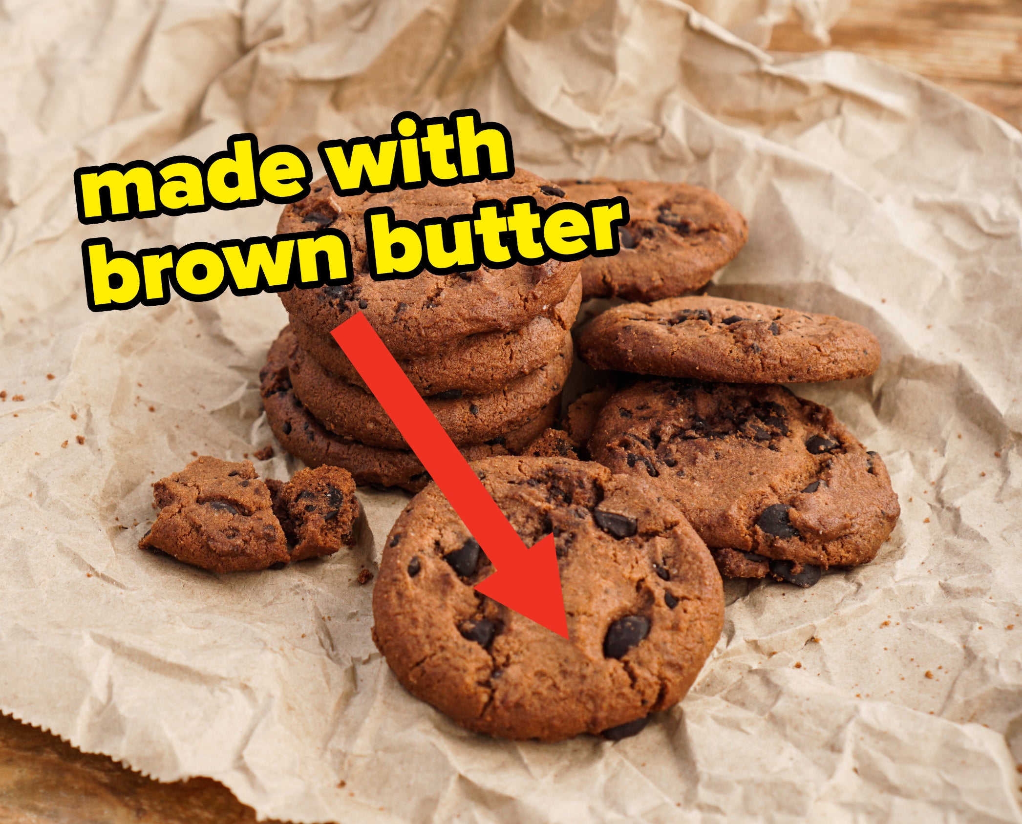 a pile of chocolate chip cookies with an arrow and words &quot;made with brown butter&quot;
