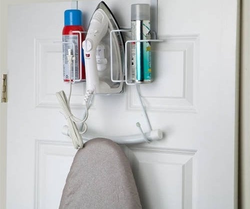 Iron and ironing board hanging on door rack