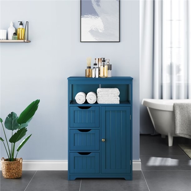 Storage cabinet in navy filled with toiletries