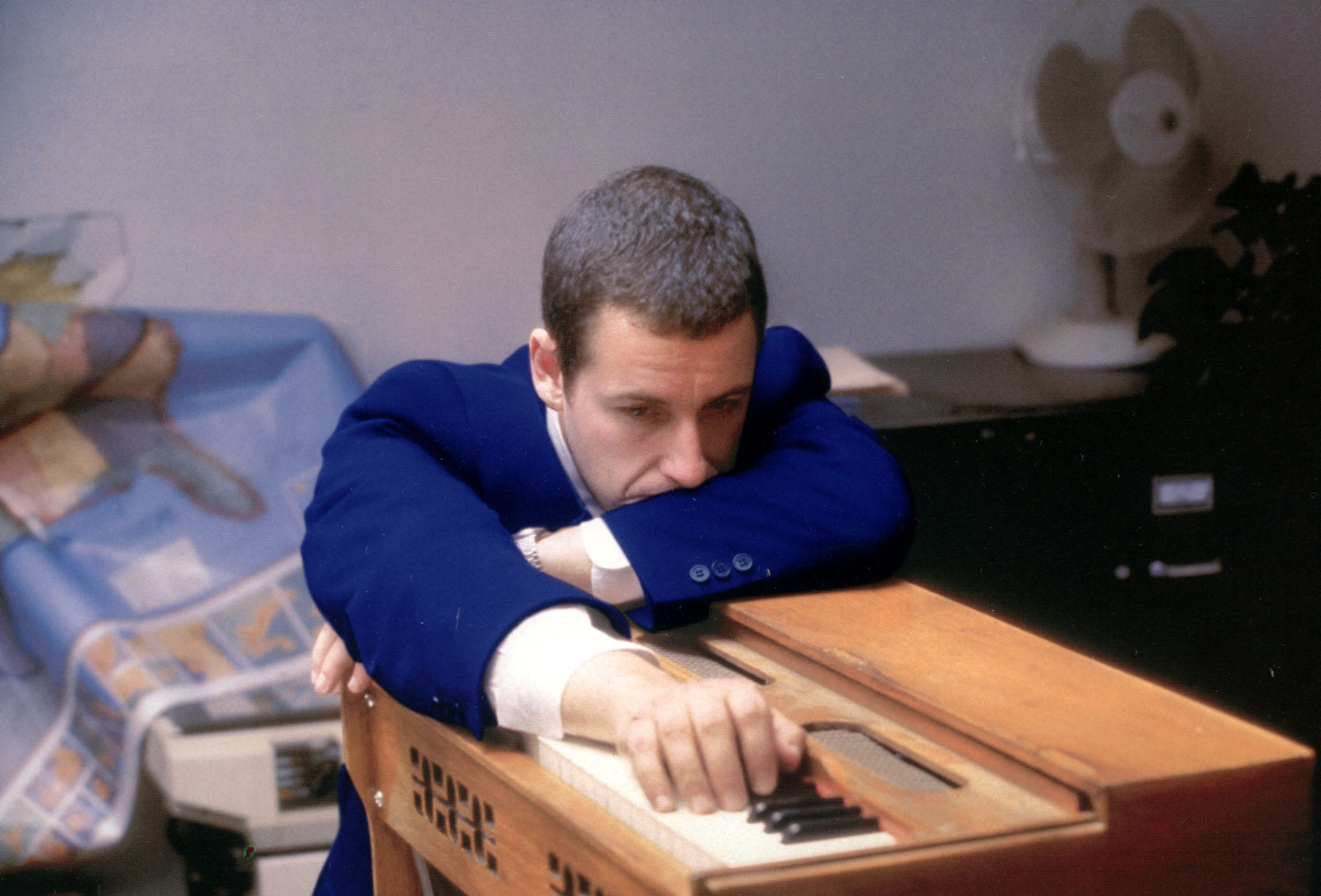 adam sandler leaning on a mini piano in punch-drunk love
