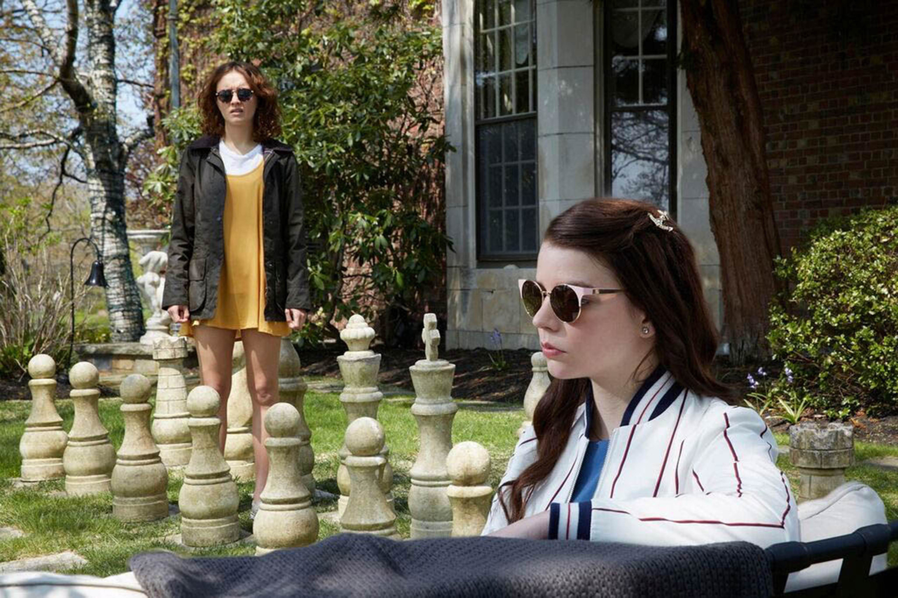 olivia cooke and anya taylor-joy in a garden strewn with chess piece statues in thoroughbreds