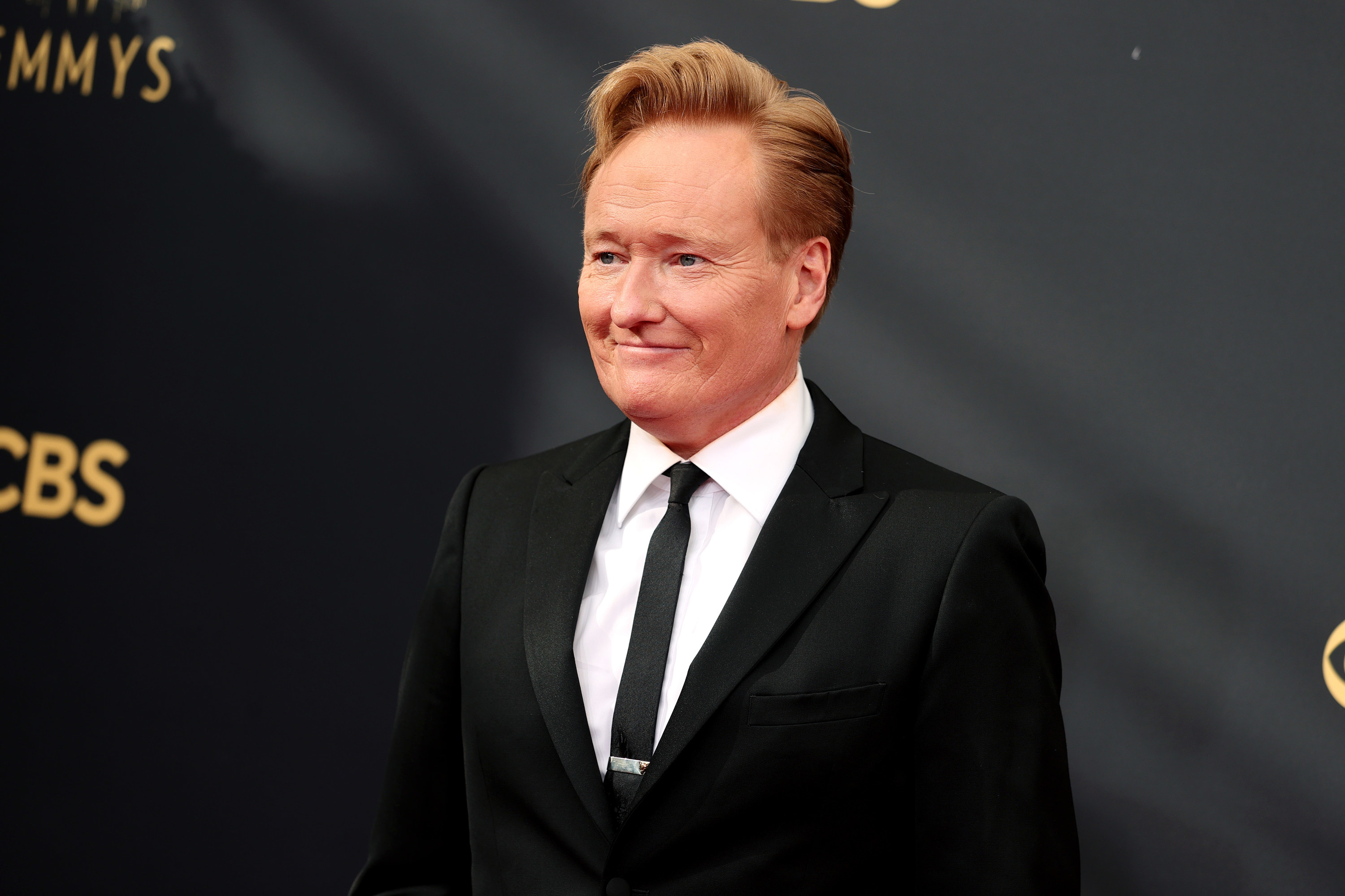 Conan OBrien smiling on the red carpet