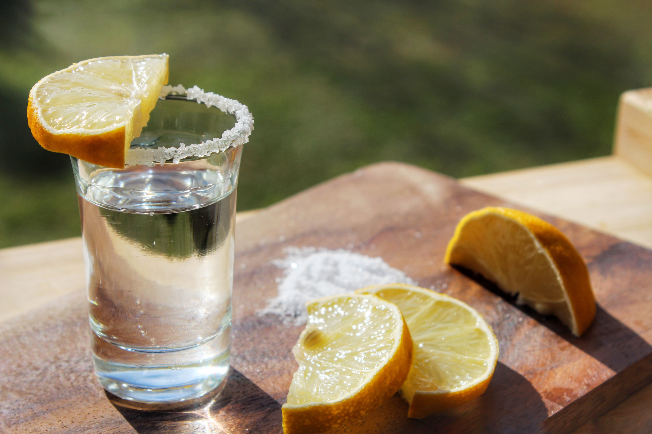 A tequila shot with sliced lemons