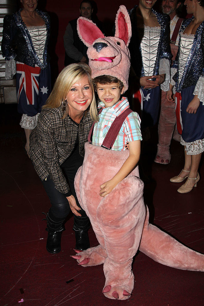 Gaten as a child in an animal costume, smiling with Olivia Newton-John