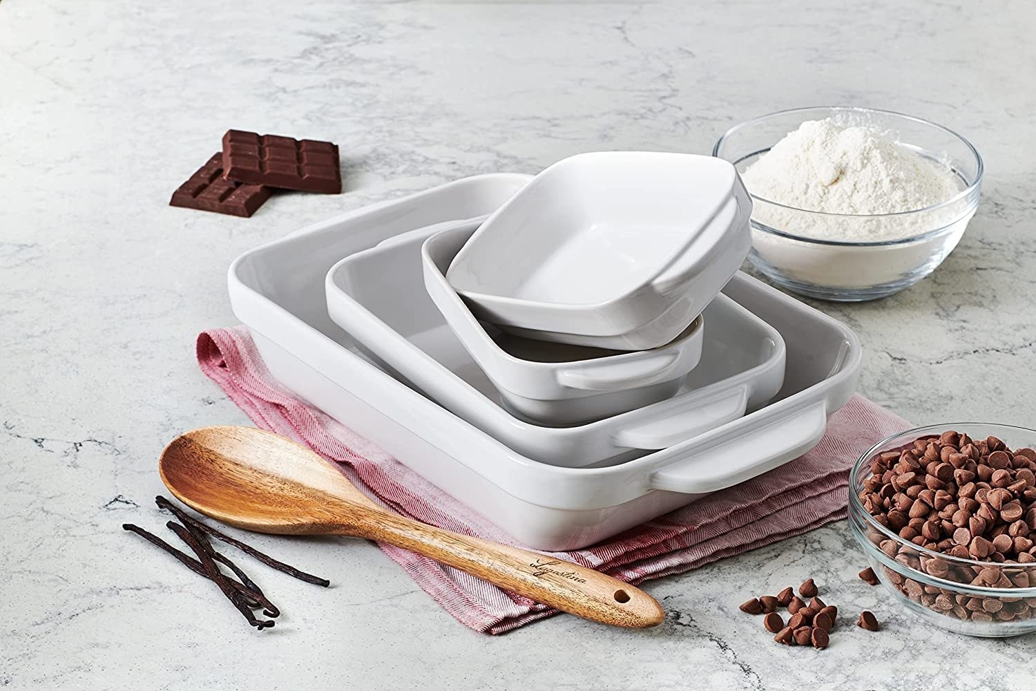 the baking dishes on a counter surrounded by bowls of flour and chocolate