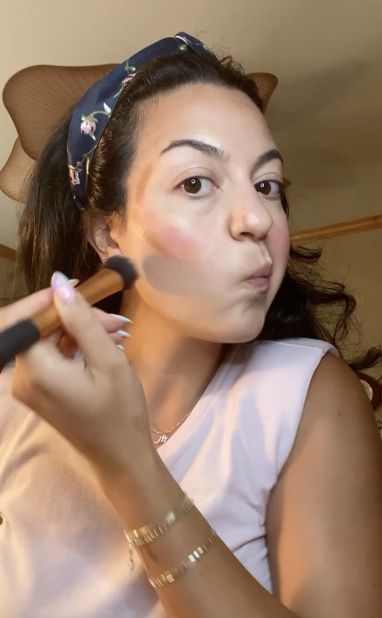 Fabiana applying makeup on her face
