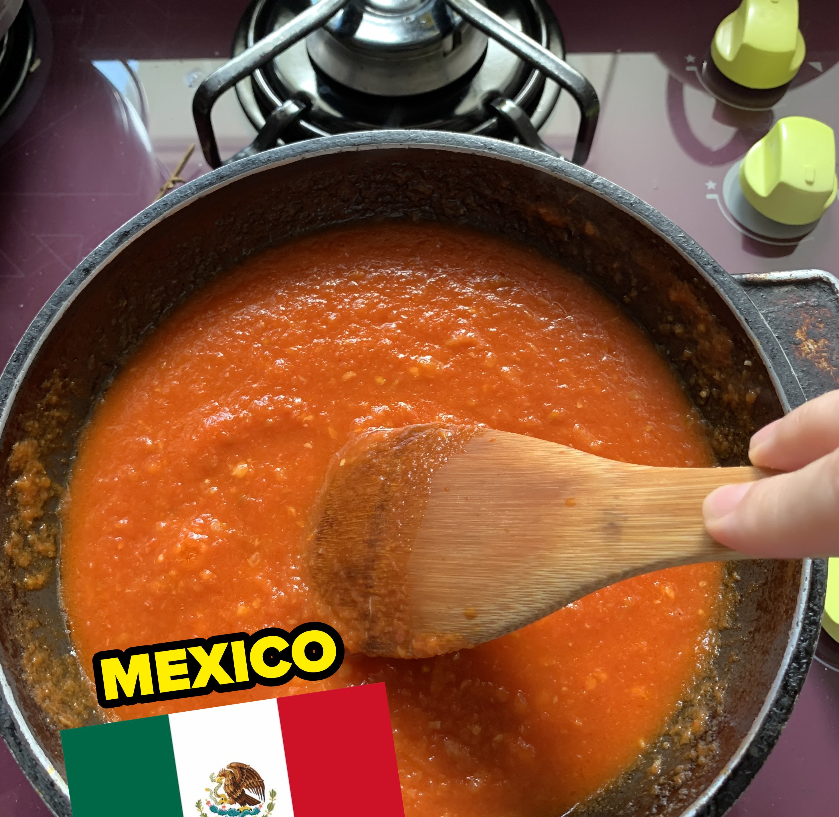 a pot of tomato sauce being stirred with a Mexican flag image