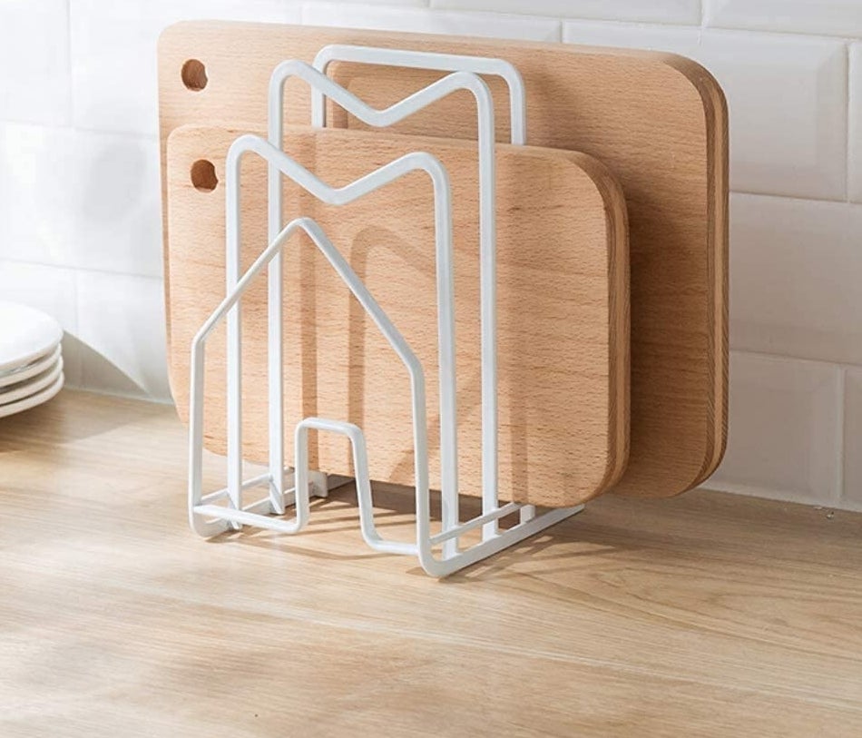the metal storage rack filled with several bamboo cutting boards