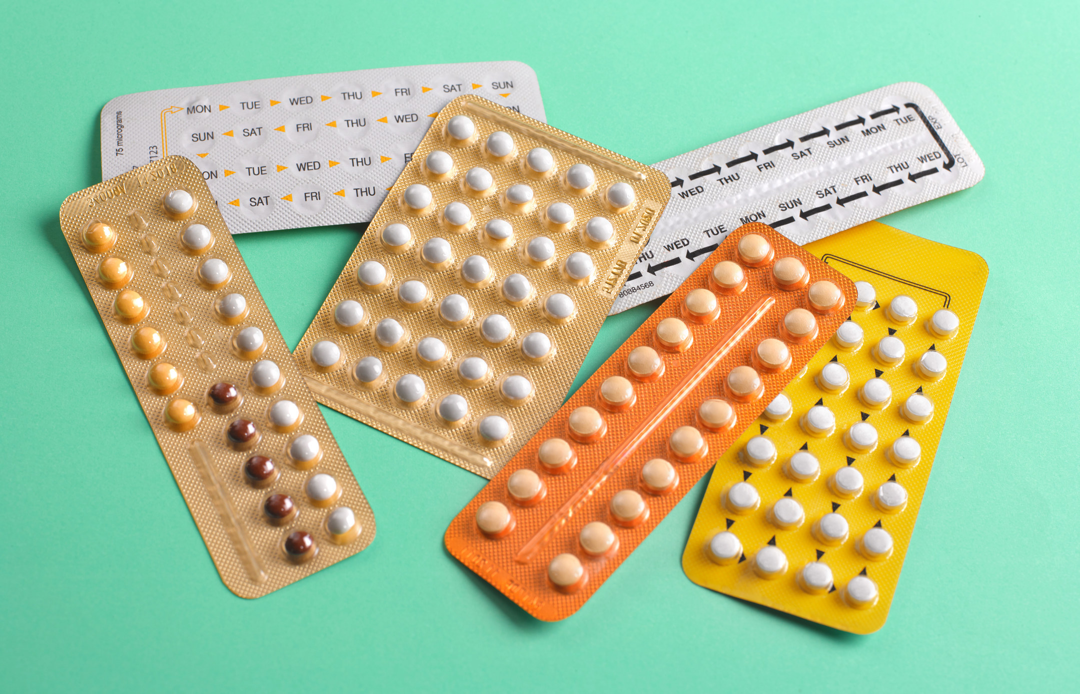 A stock image of birth control pill packs on a green background