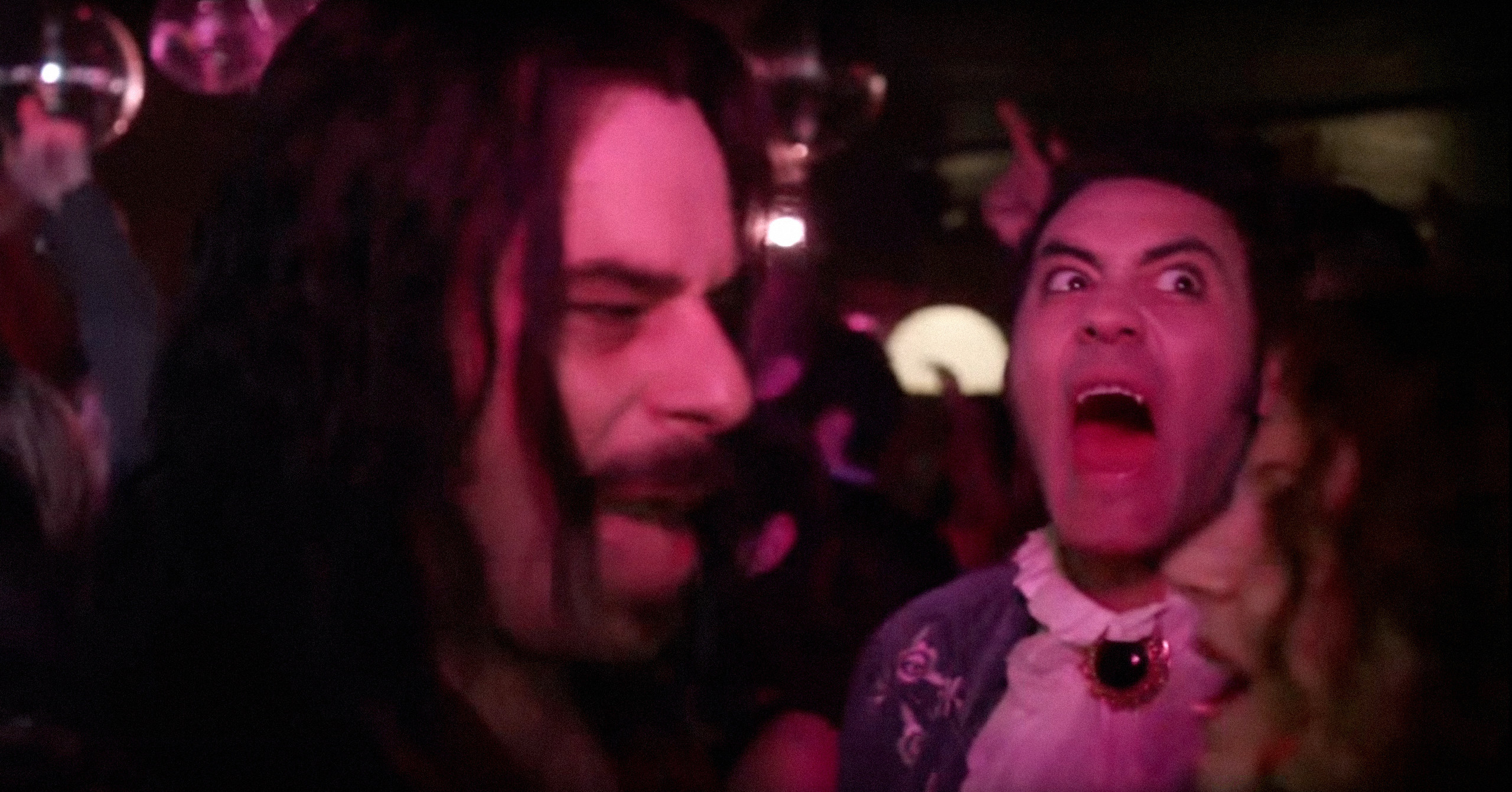 Two goofy looking vampires in a nightclub