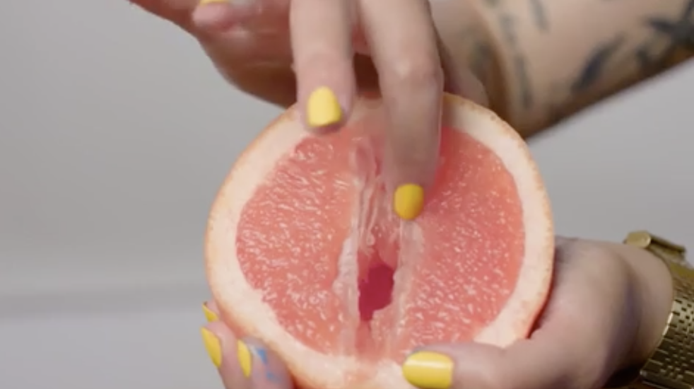 A woman spreading a grapefruit open