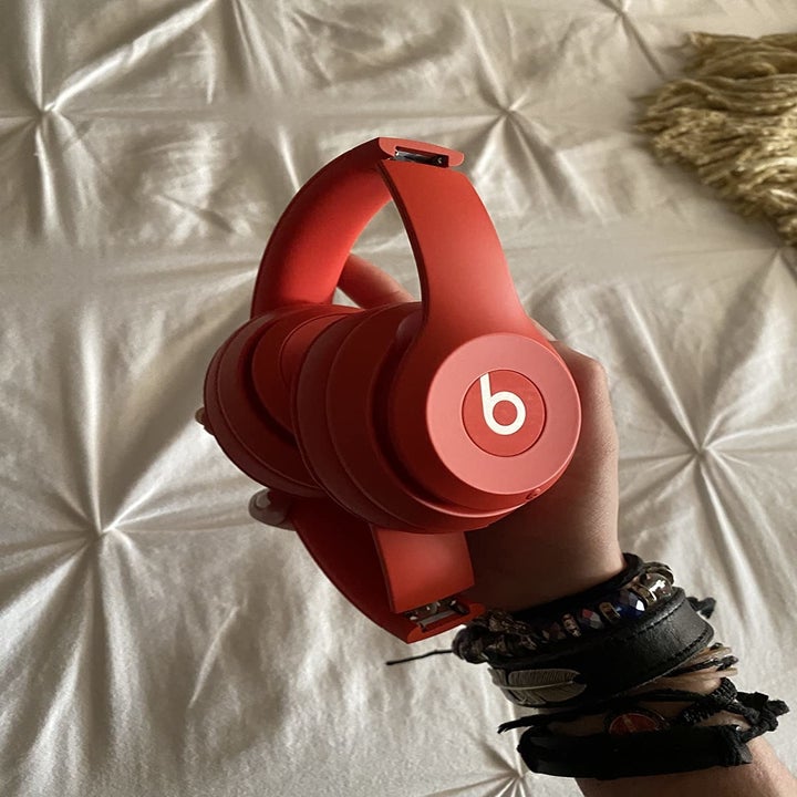 reviewer holding a pair of red headphones