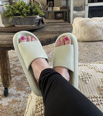 reviewer wearing the light green sandals with black leggings