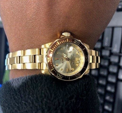 reviewer&#x27;s wrist wearing the gold watch