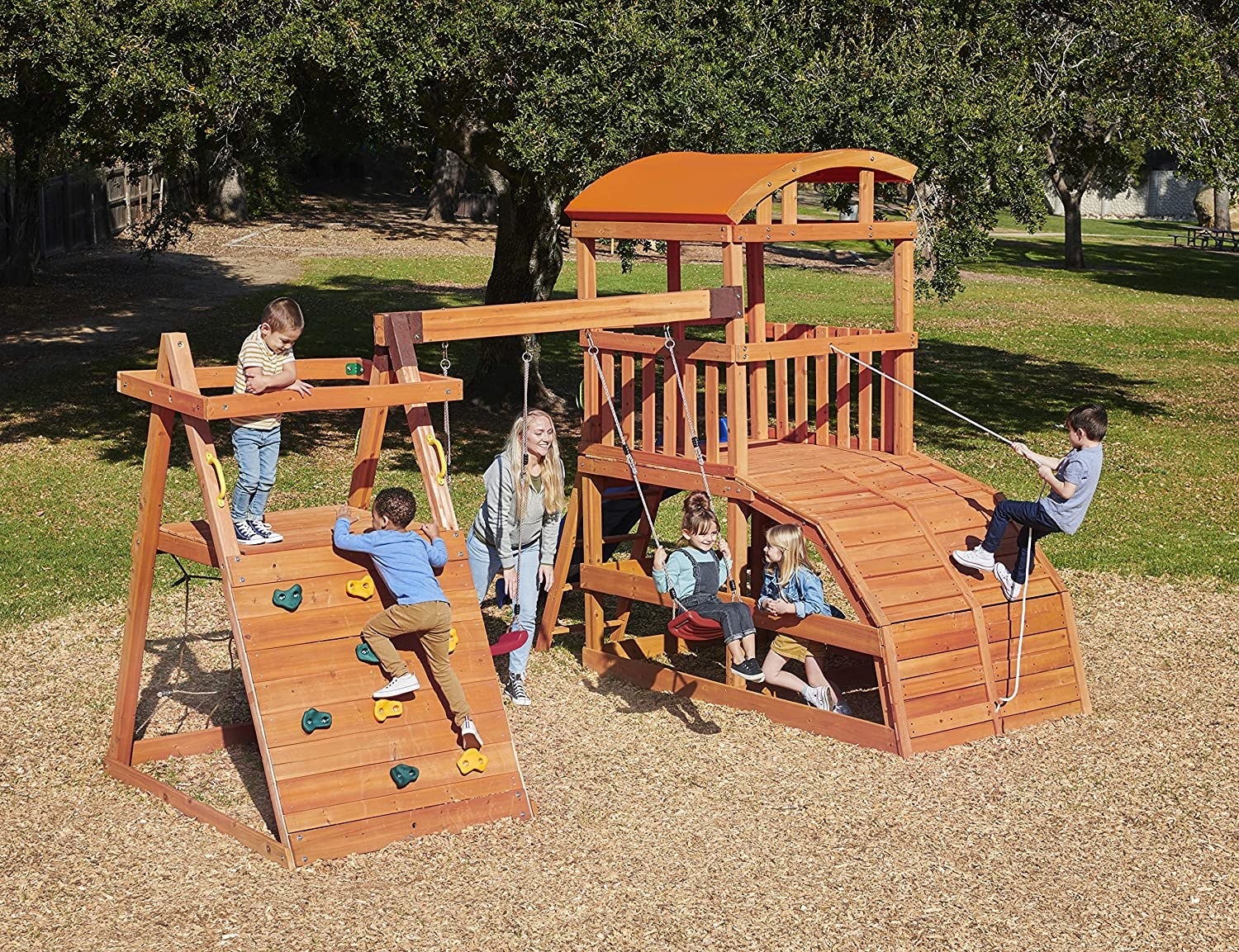 several kids playing on a background wooden play set