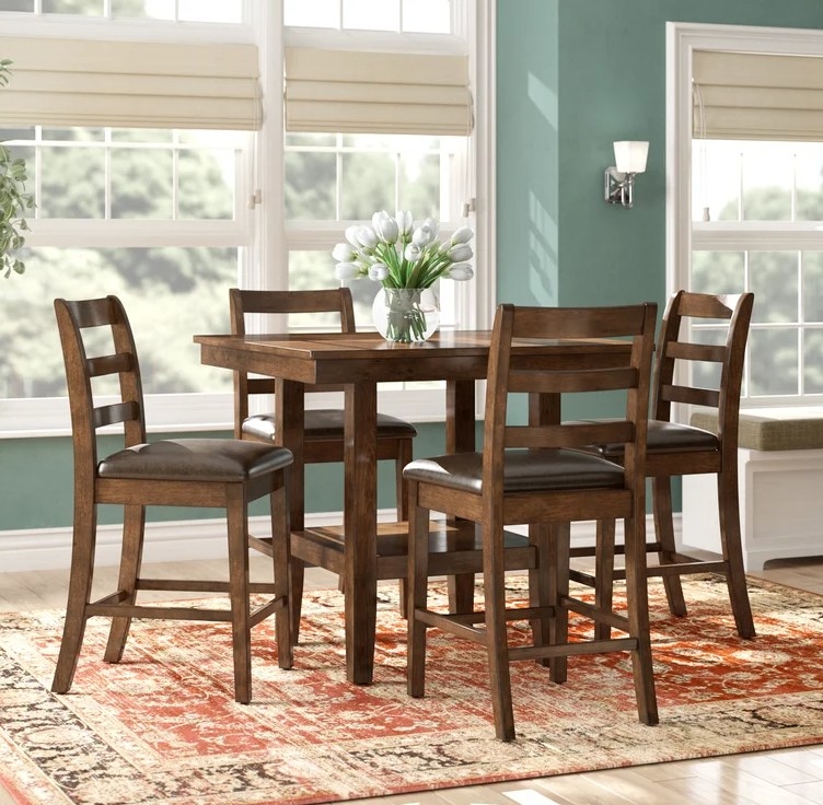 the brown dining table and four dining chairs with dark brown leather seat cushions