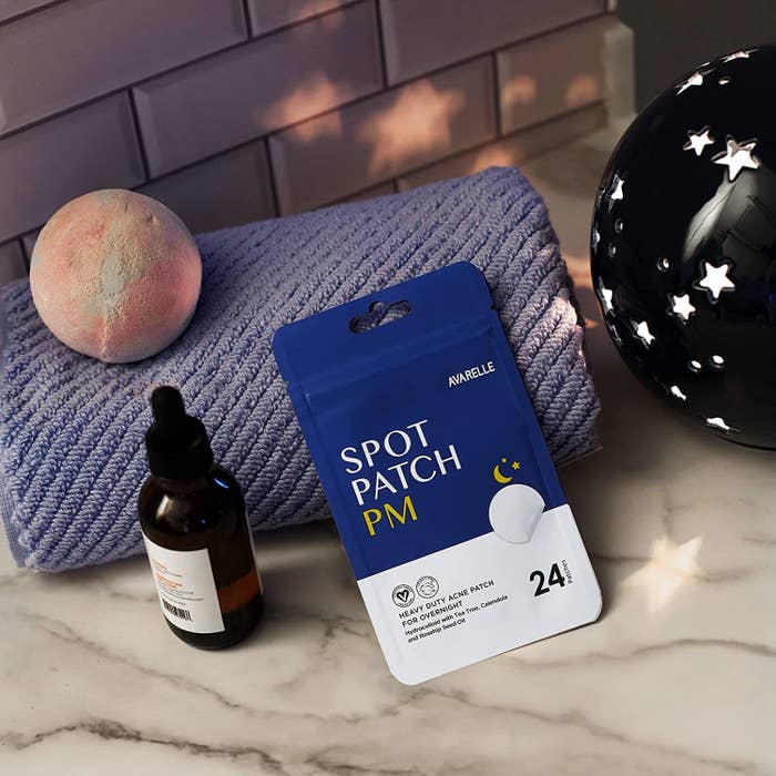 A pack of pimple patches on a counter resting on a towel