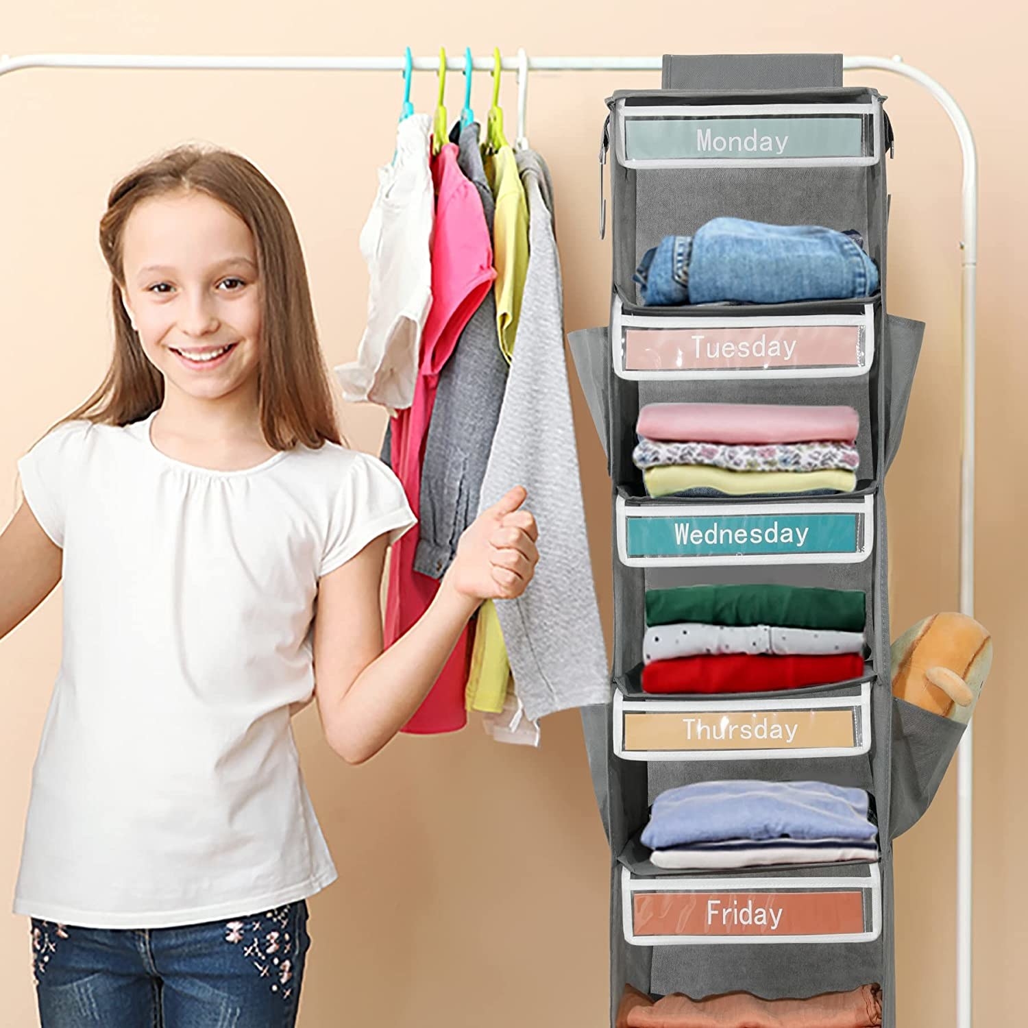 child standing beside vertical hanging days of the week cubby closet holder