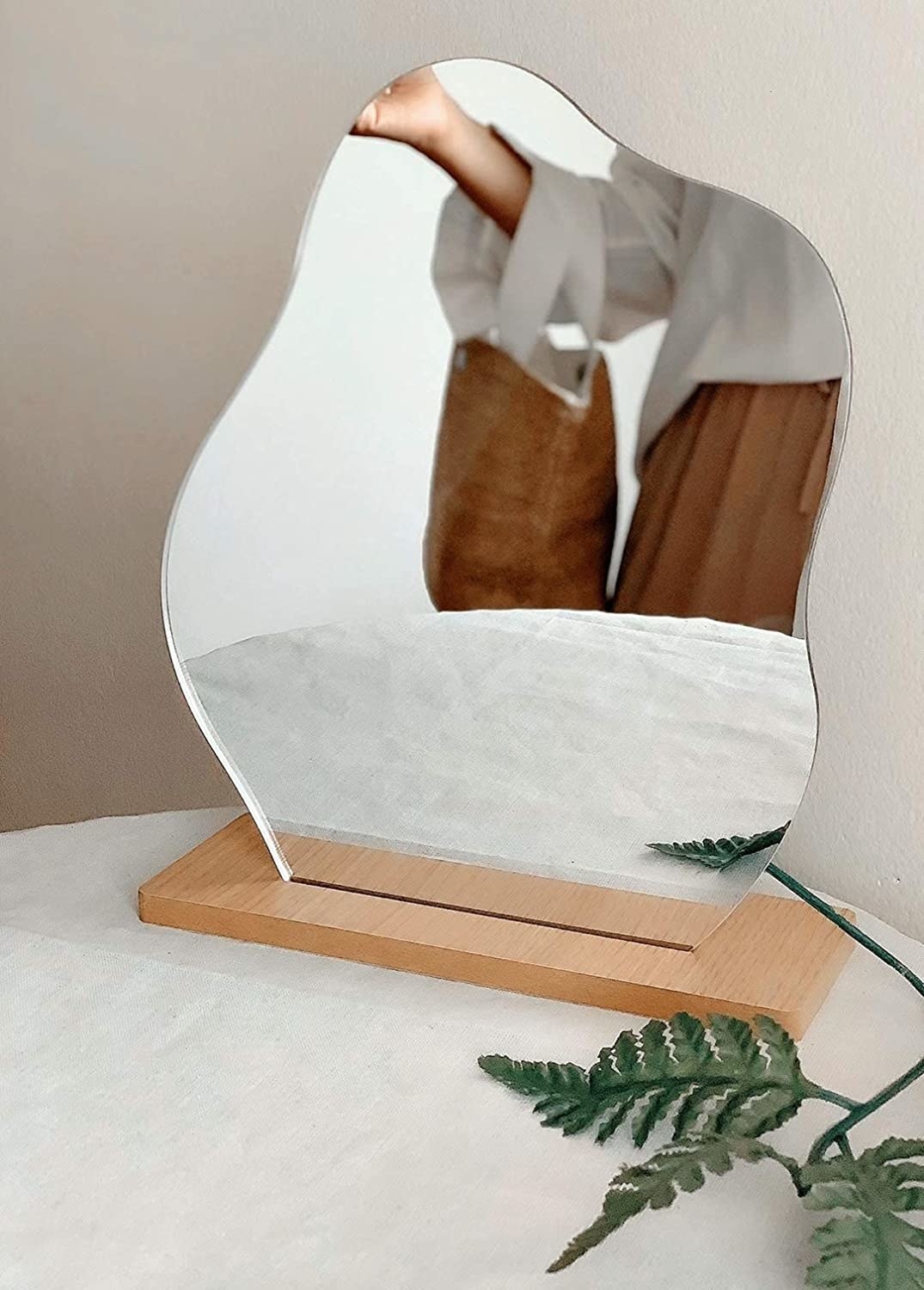 A cloud-shaped mirror on a wooden stand