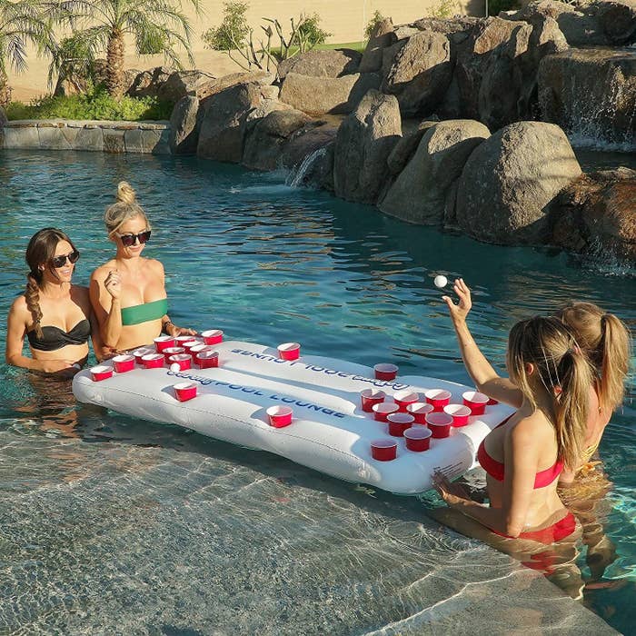 people playing beer pong in a pool