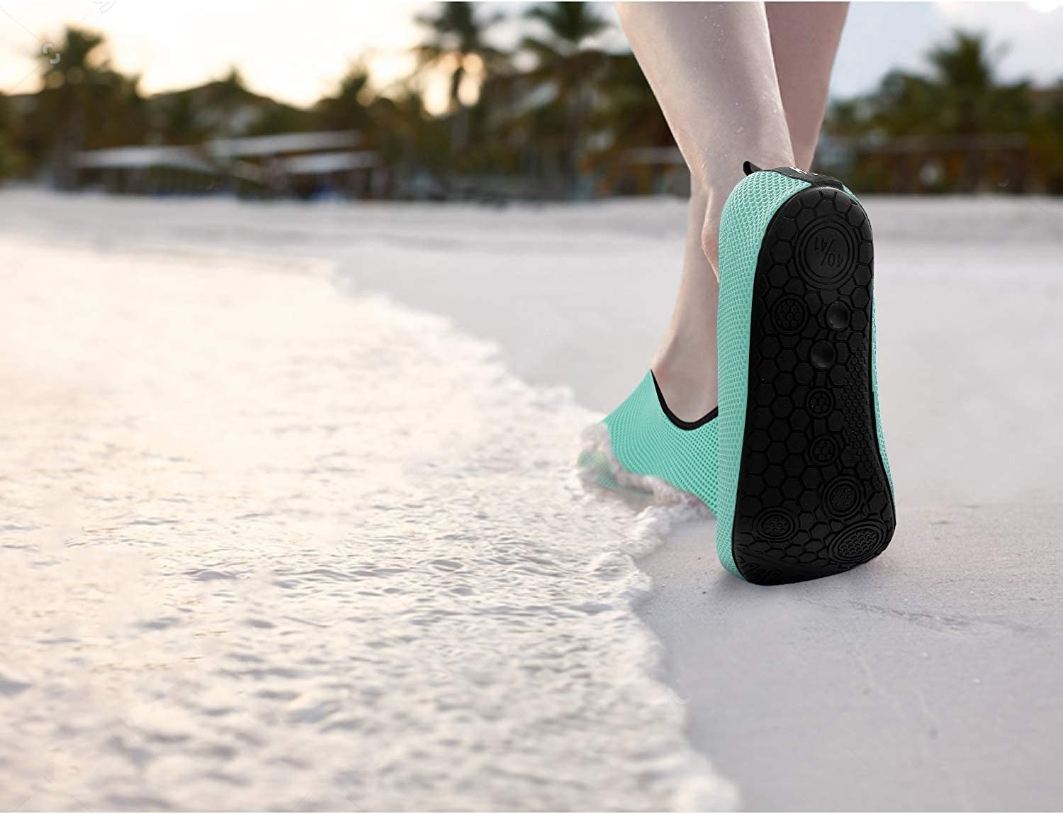 someone walking on a beach in the water shoes