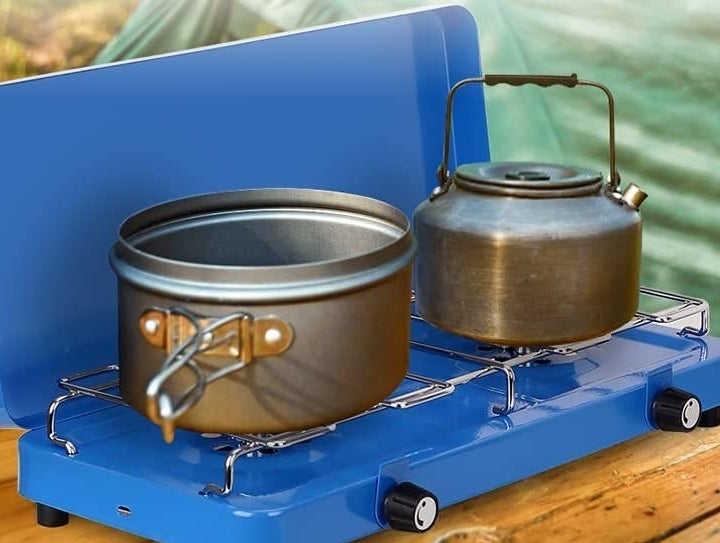 two pots on two burners on a camping stove
