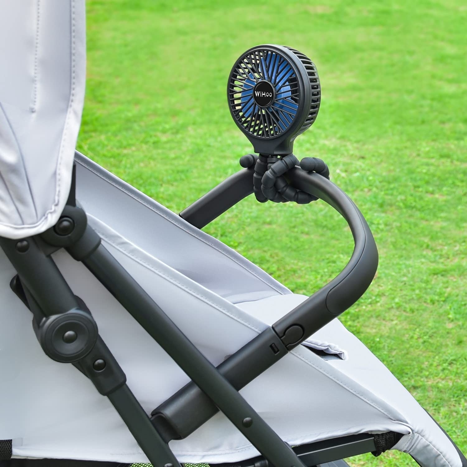 the black fan wrapped around the handle of a stroller