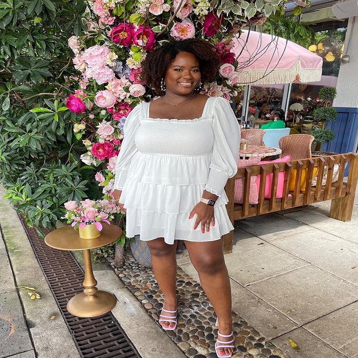 reviewer wearing the white dress