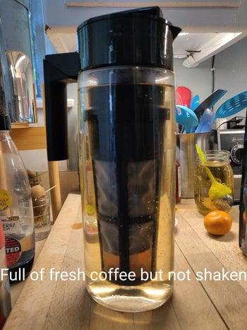 before photo of the cold brew maker with water in it and coffee in the filter before it's been shaken