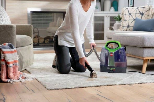 A model using the cleaning tool on her area rug