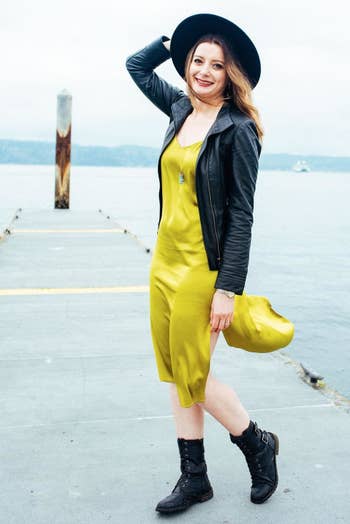 reviewer wearing the chartreuse dress with a leather jacker and boots