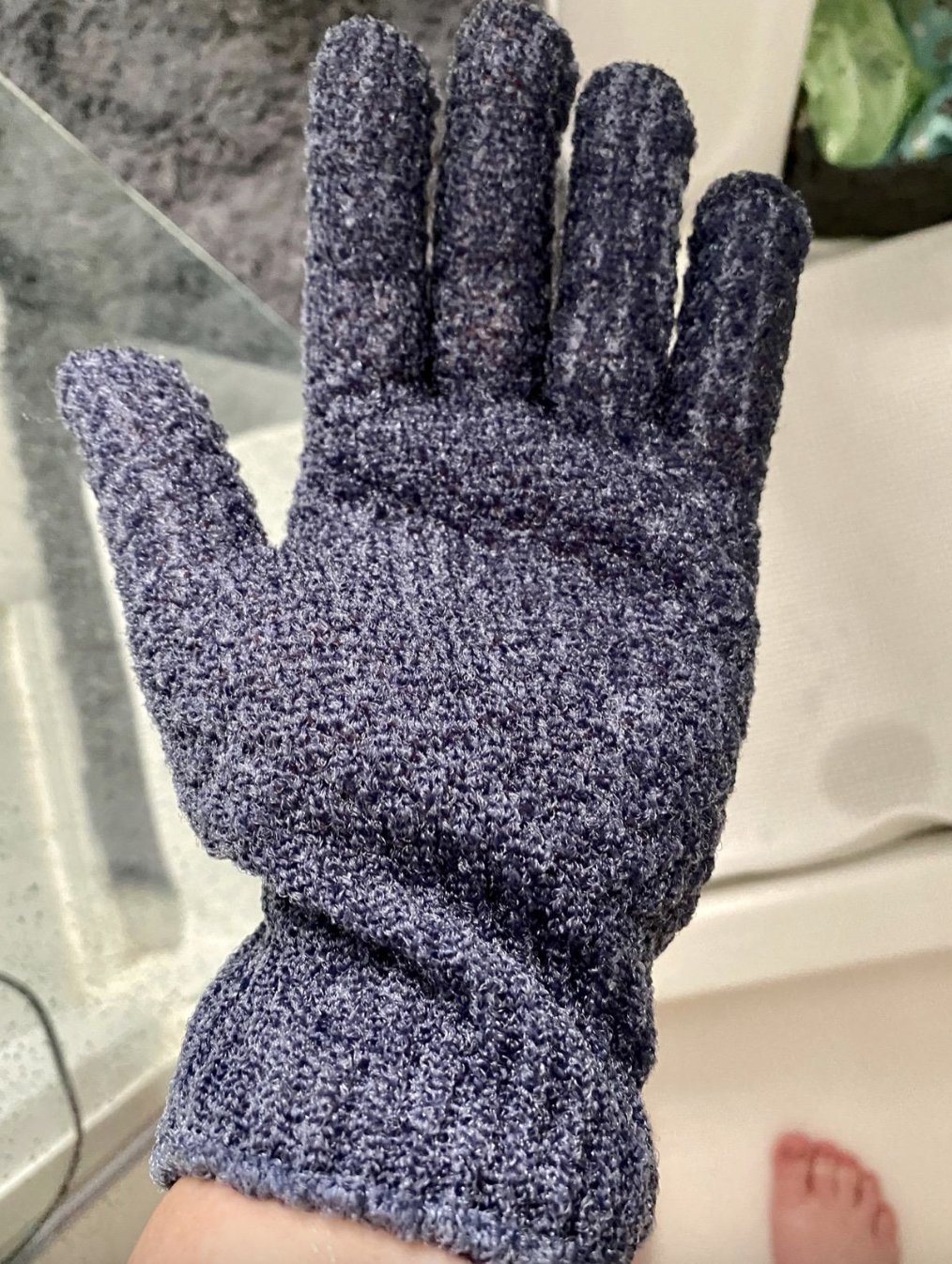 reviewer photo of them wearing blue fingered glove in the shower