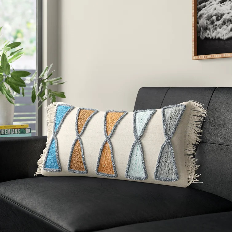 Pillow adorned with pattern of colored triangles on black sofa