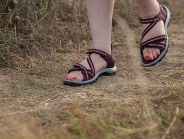 a model wearing the sandals while hiking