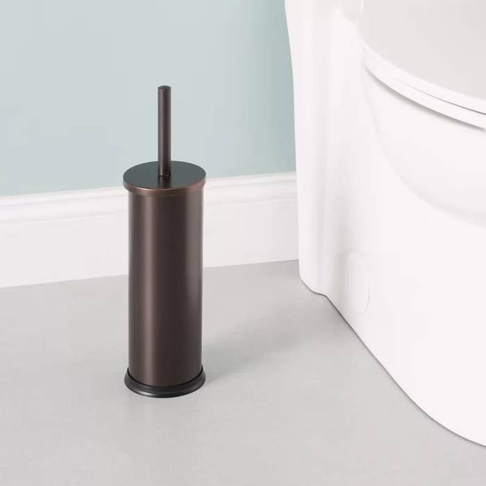 A bronze steel toilet bowl brush and holder