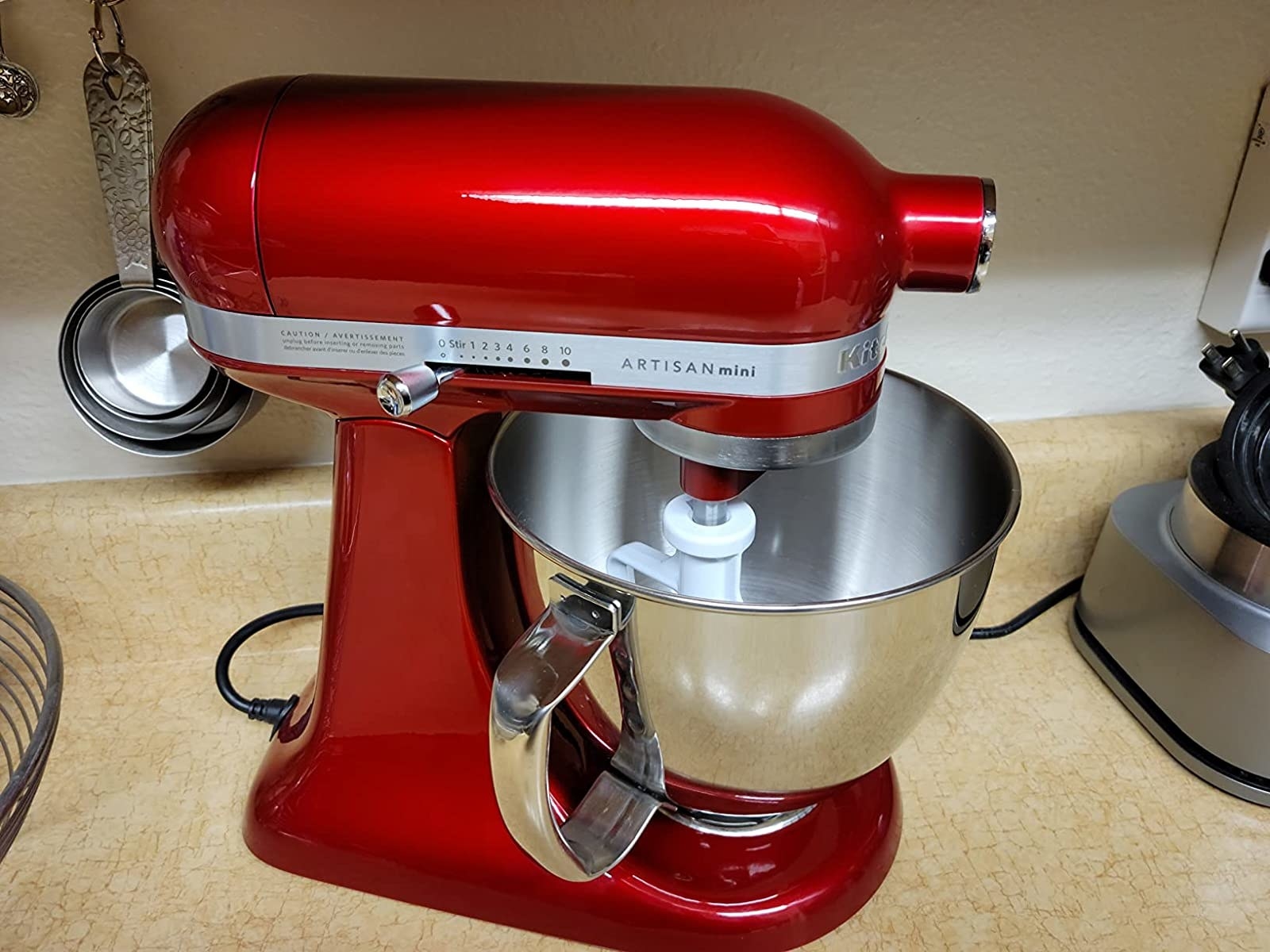 A red stand mixer is shown on a kitchen countertop