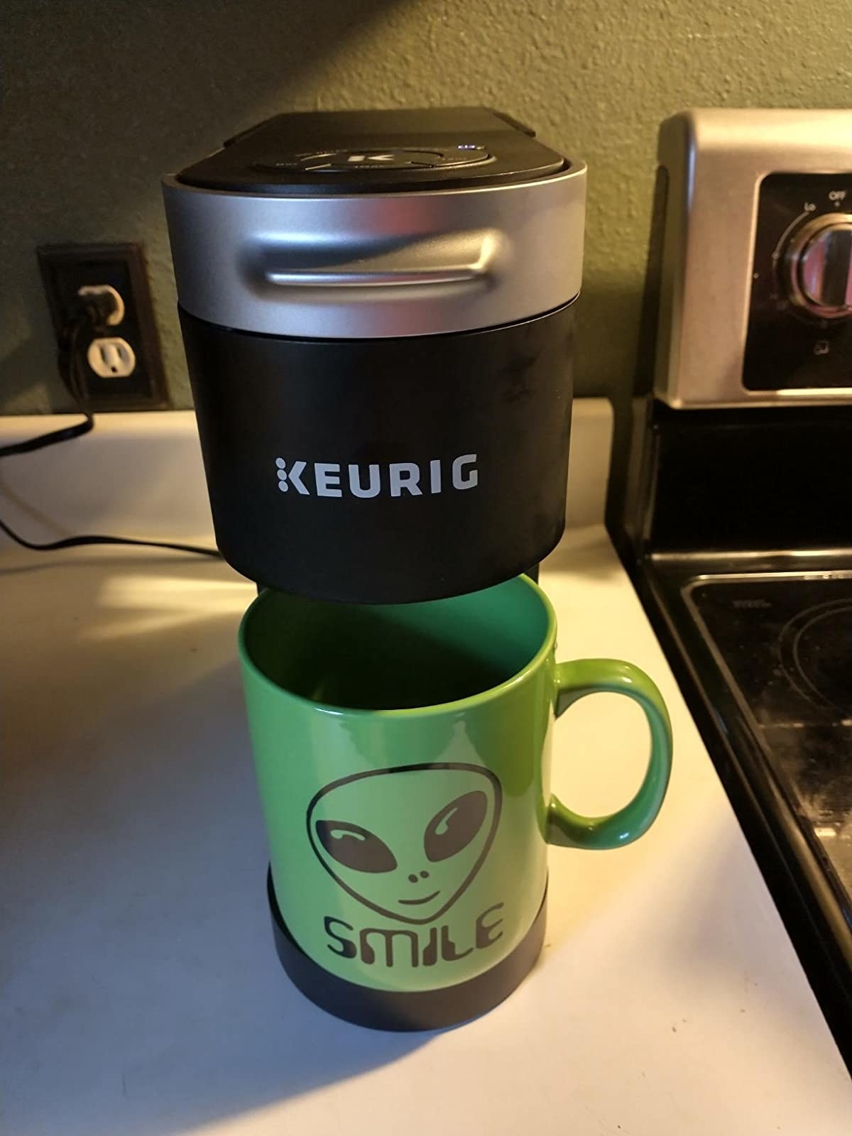 reviewer image of a single-serve keurig machine with a green mug under it