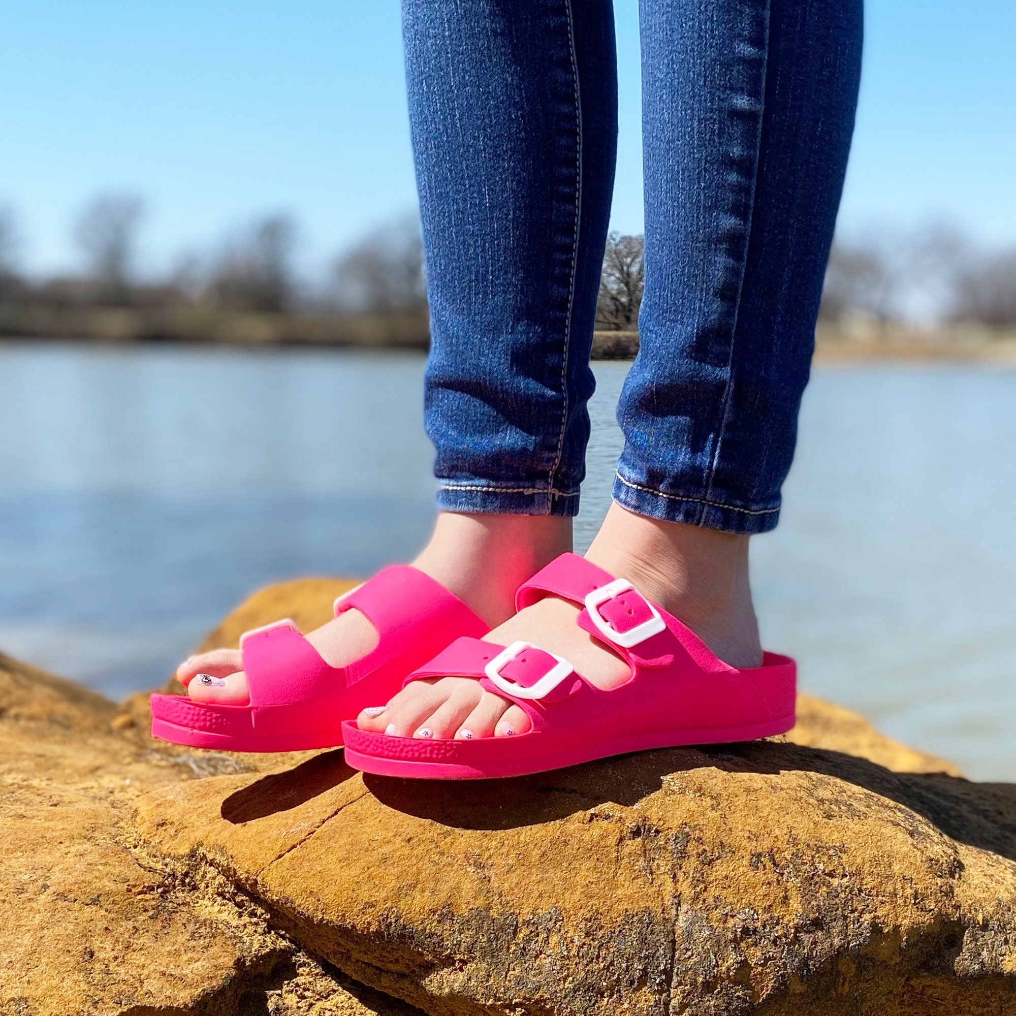 a model wearing the sandals in hot pink