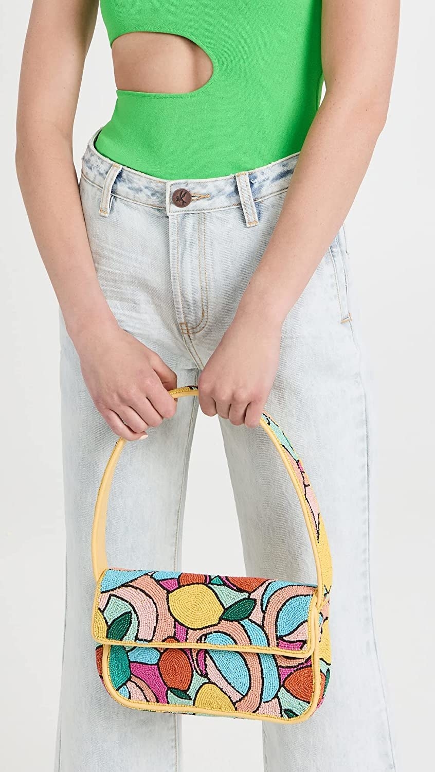 model holding multicolor fruit and abstract pattern baguette bag