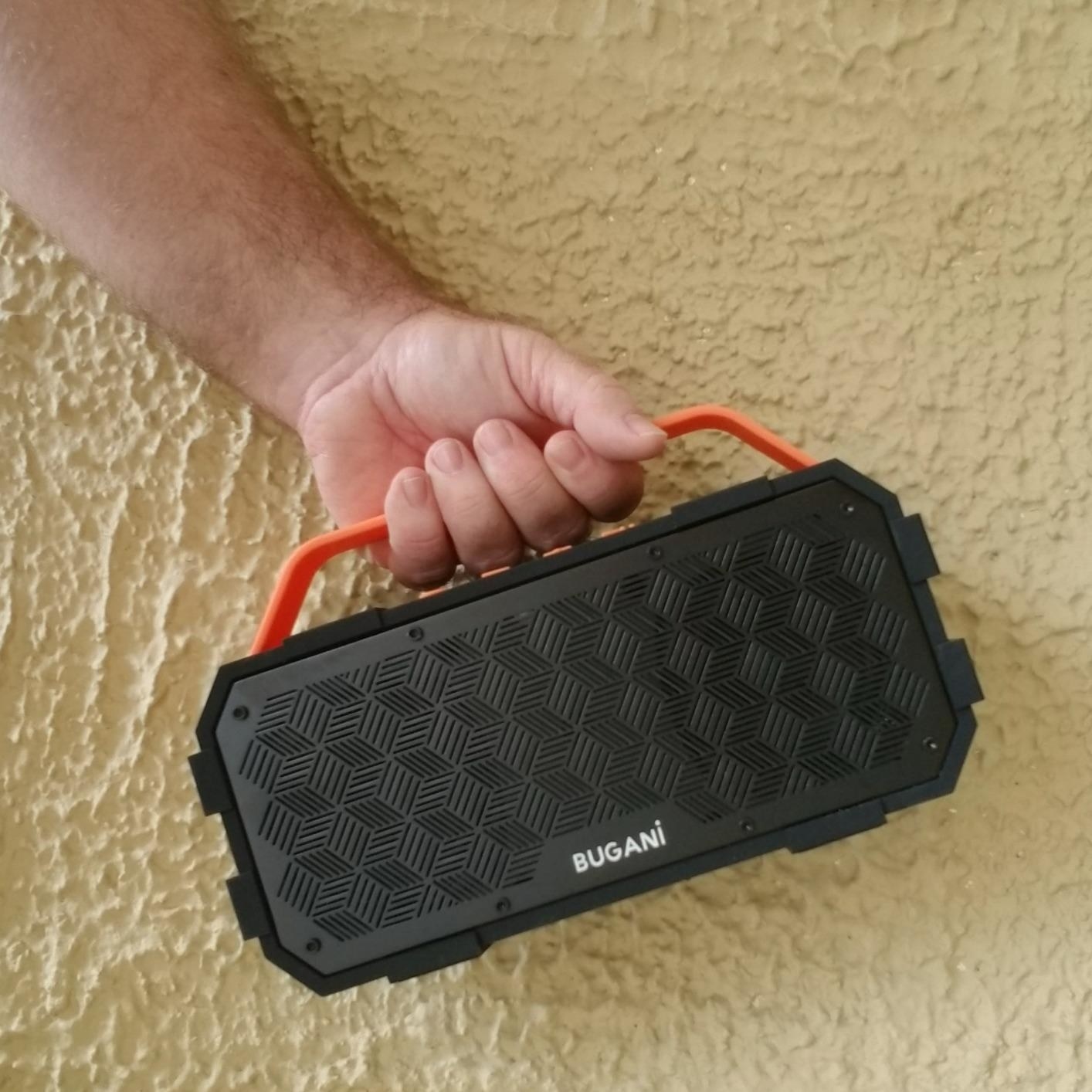 Reviewer holding black and orange speaker