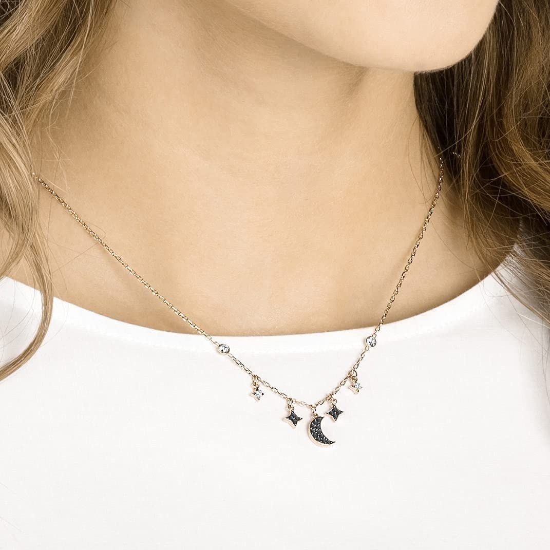 a person wearing the swarovski necklace with moon charms on it