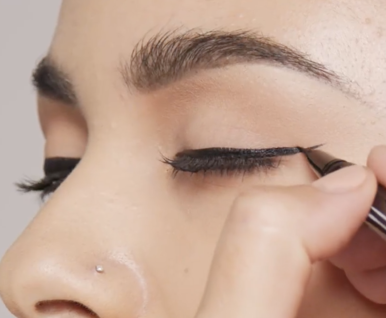 A person putting eyeliner on their eyelid