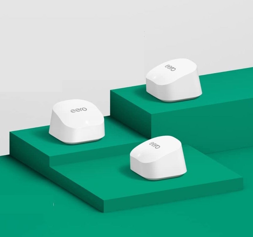 a trio of mesh wifi routers on a colourful background