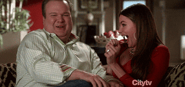 gif of two characters from modern family doing the shimmy and smiling