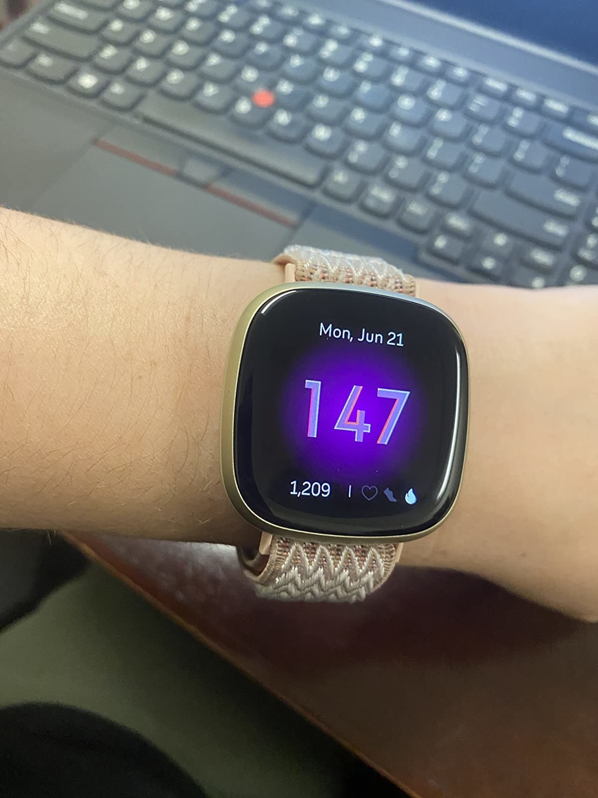 customer with watch with square digital display reading heart rate and step count