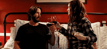 Keanu Reeves and Winona Ryder drinking wine in bed